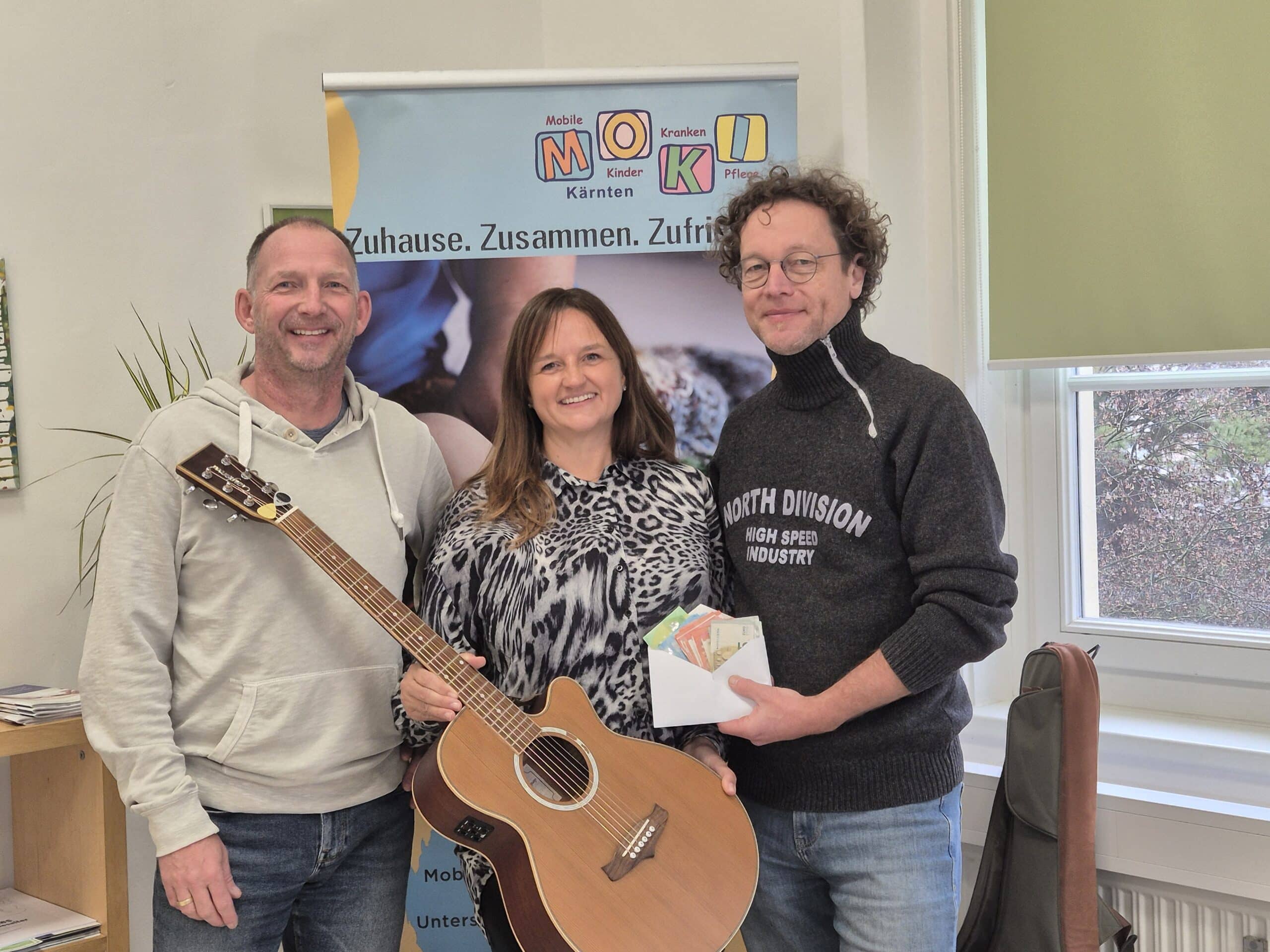 Musiker mit Gitarre bei der Spendenübergabe zum Wölfnitzer Advent