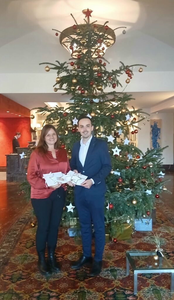 Spendenübergabe vor dem Christbaum im Schlosshotel