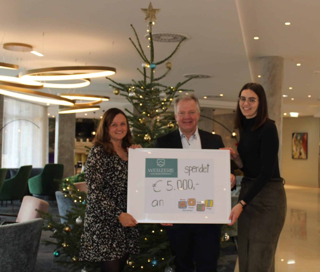 Scheckübergabe über 5.000 Euro vor dem Christbaum im Werzers Hotel Resort Pörtschach