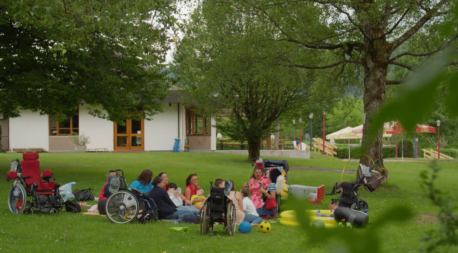 Kinder und Betreuerinnen bei der Sommerbetreuung im Garten