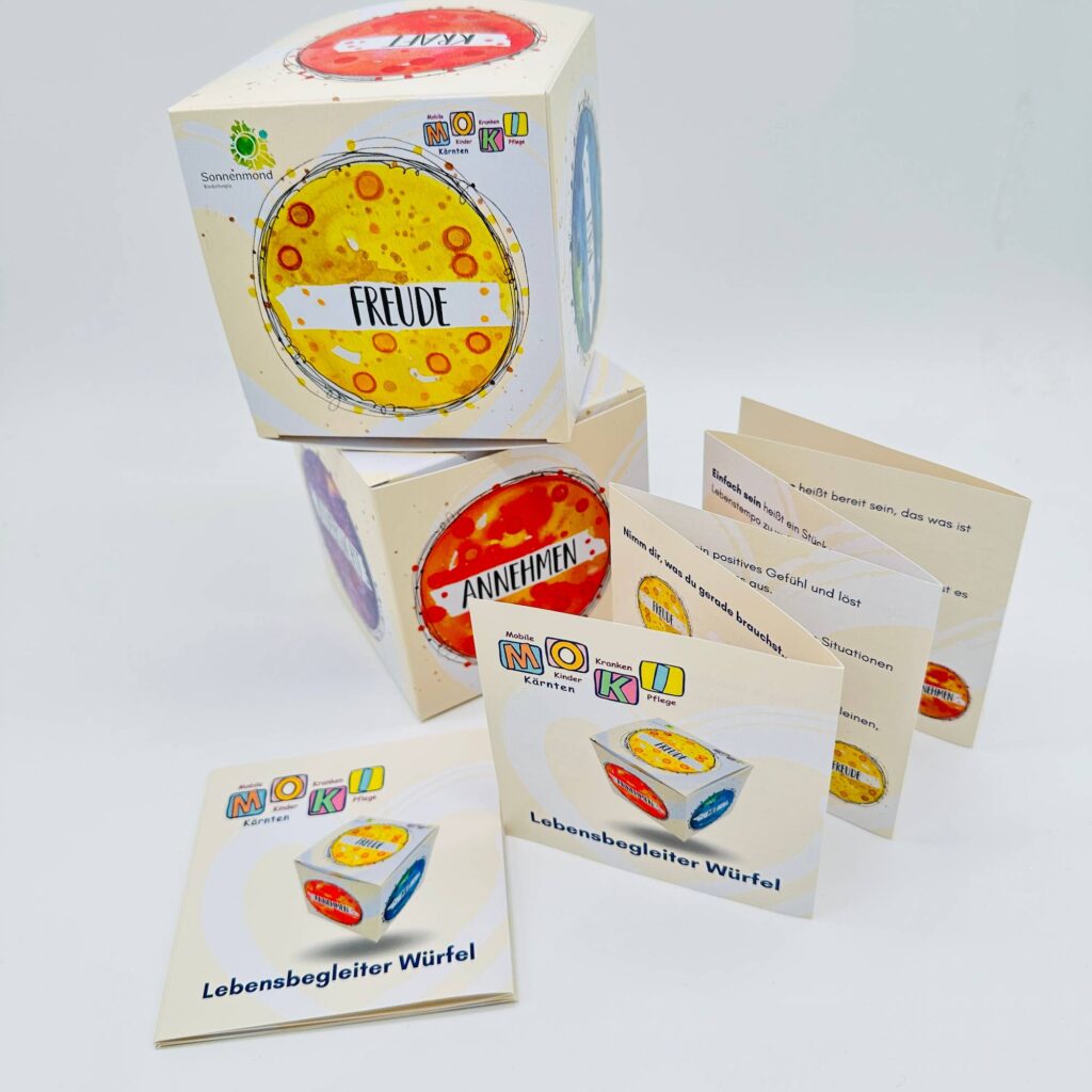Lebensbegleiterwürfel von MOKI Kärnten mit aufgeklapptem Leporello